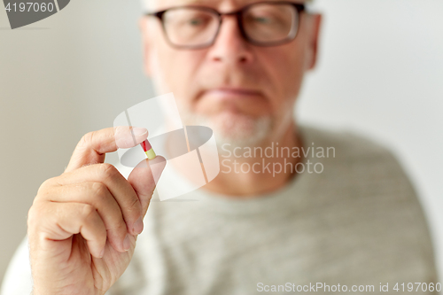 Image of close up of senior man with medicine pill