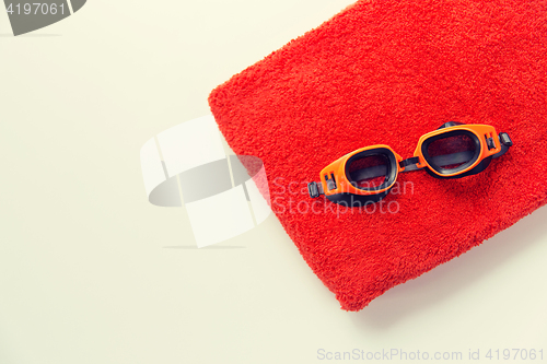 Image of close up of swimming goggles and towel