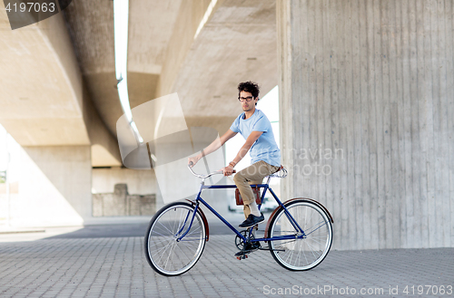 Image of young hipster man riding fixed gear bike