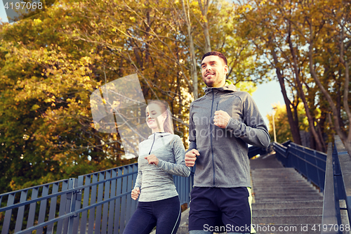 Image of happy couple running downstairs in city