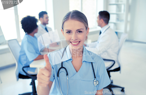 Image of happy doctor over group of medics at hospital