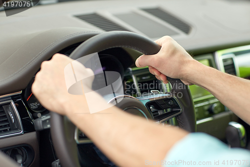 Image of close up of male hands driving car