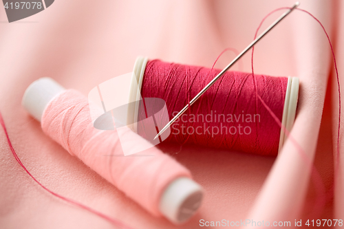 Image of red thread spool on cloth