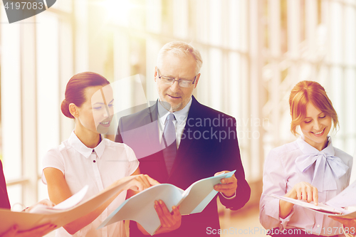 Image of business team with folders meeting at office