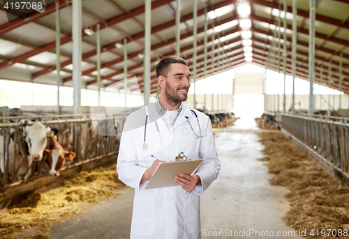 Image of veterinarian with cows in cowshed on dairy farm