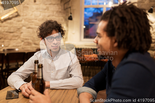 Image of happy male friends drinking beer at bar or pub