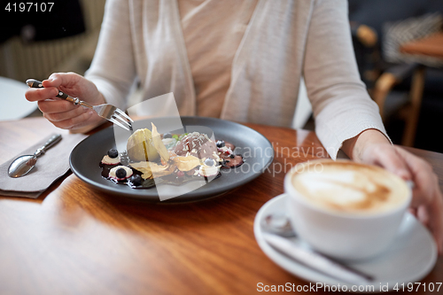 Image of woman eating ice cream dessert with coffee at cafe