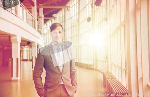 Image of young businessman in suit at office building hall