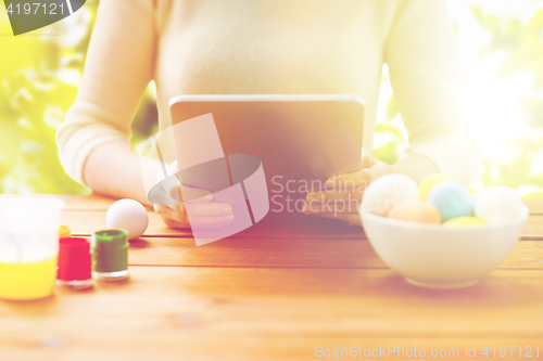 Image of close up of woman with tablet pc and easter eggs