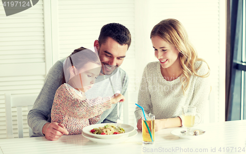 Image of happy family having dinner at restaurant or cafe