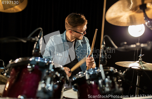 Image of male musician playing drums and cymbals at concert