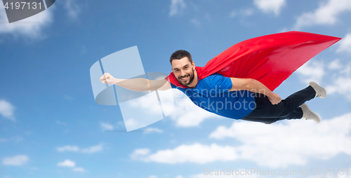 Image of happy man in red superhero cape flying over sky