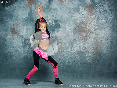 Image of Young girl break dancing on wall background.