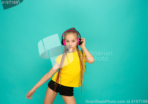 Image of The attractive girl with headphones on blue background