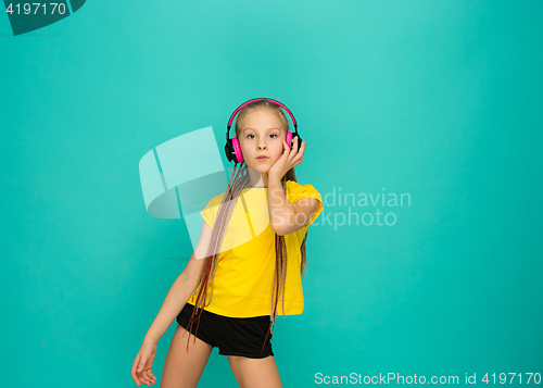 Image of The attractive girl with headphones on blue background