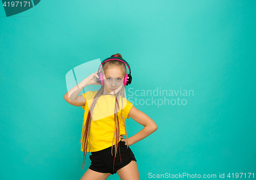 Image of The attractive girl with headphones on blue background