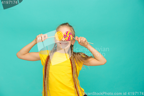 Image of The teen girl with colorful lollipop on a blue background