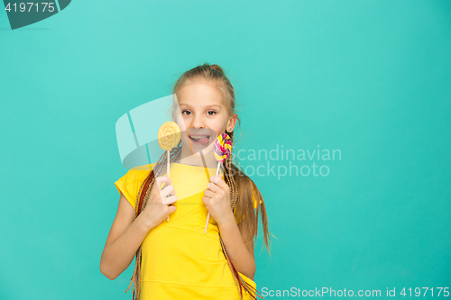 Image of The teen girl with colorful lollipop on a blue background