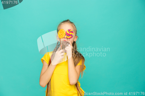 Image of The teen girl with colorful lollipop on a blue background