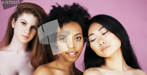 Image of three different nation girls with diversuty in skin, hair. Asian, scandinavian, african american cheerful emotional posing on pink background, woman day celebration, lifestyle people concept 