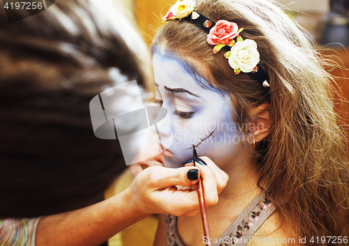 Image of little cute child making facepaint on birthday party, zombie Apo