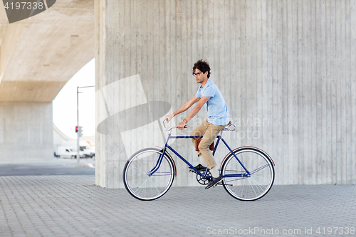 Image of young hipster man riding fixed gear bike