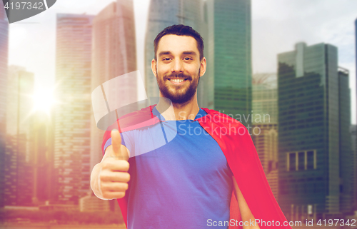Image of happy man in red superhero cape showing thumbs up