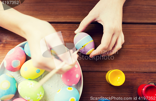 Image of close up of woman hands coloring easter eggs