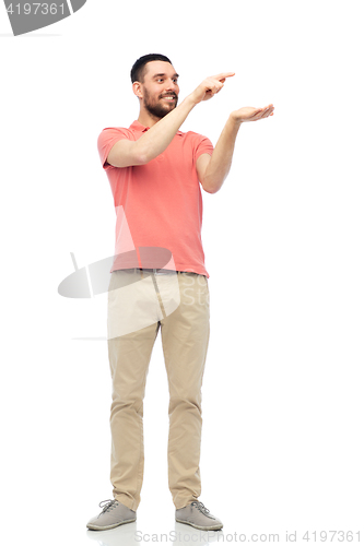 Image of happy man holding something imaginary on hand