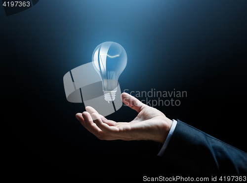 Image of close up of businessman hand with light bulb