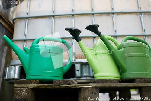 Image of watering cans at farm water tank