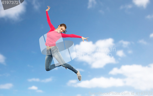Image of happy young woman jumping in air or dancing