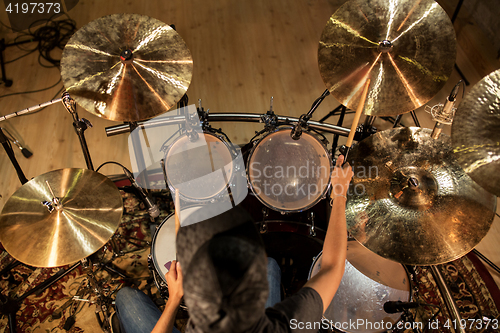 Image of male musician playing drums and cymbals at concert
