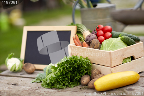 Image of close up of vegetables with chalkboard on farm