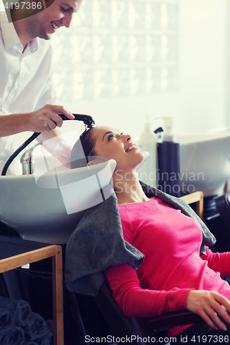 Image of happy young woman at hair salon