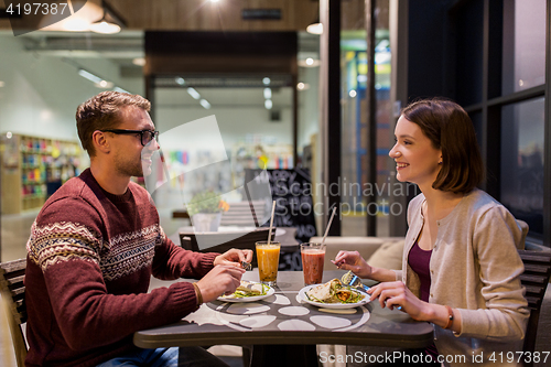 Image of happy couple eating dinner at vegan restaurant