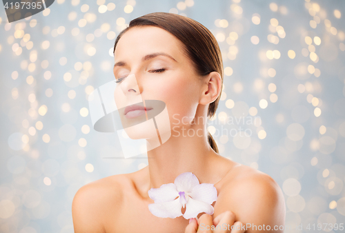 Image of beautiful young woman with orchid flower