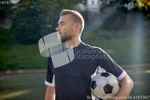 Image of soccer player with ball on football field