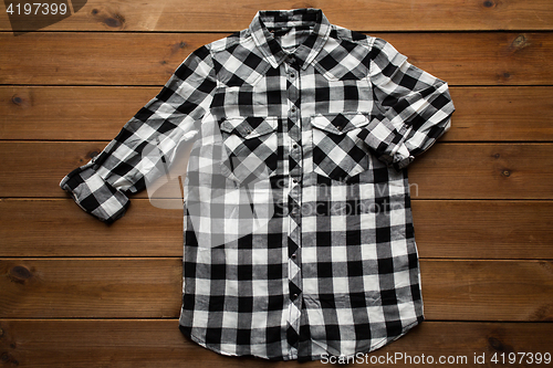 Image of checkered shirt on wooden background