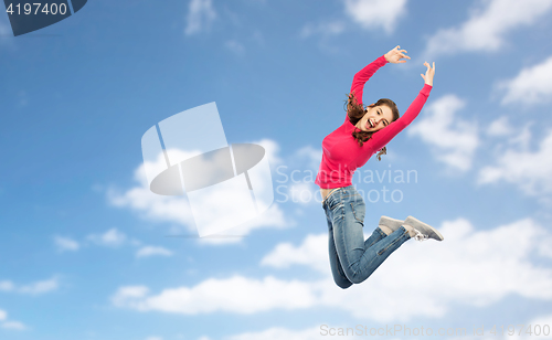 Image of happy young woman jumping in air or dancing