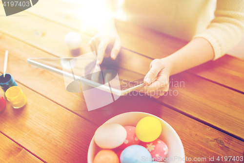 Image of close up of woman with tablet pc and easter eggs