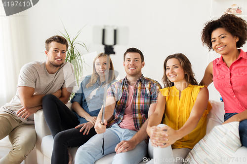 Image of happy friends taking selfie by smartphone at home