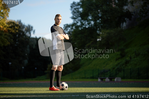 Image of soccer player with ball on football field