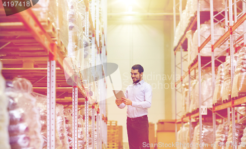 Image of happy businessman with tablet pc at warehouse