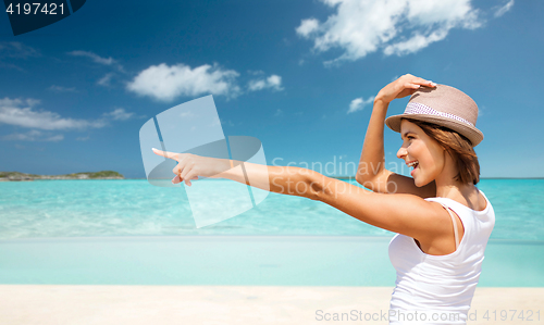 Image of happy young woman in hat on summer beach