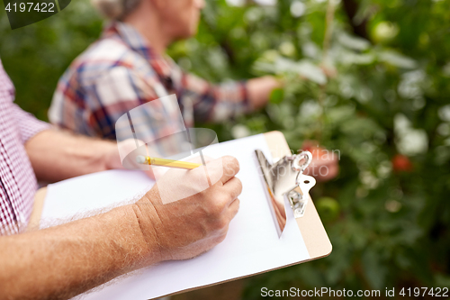 Image of senior couple with clipboard at farm
