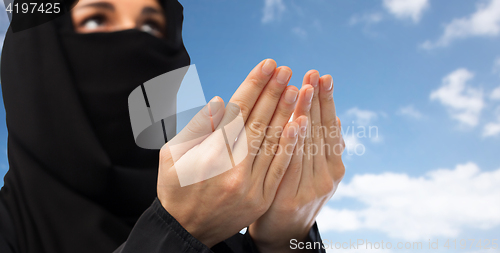 Image of close up of praying muslim woman in hijab over sky