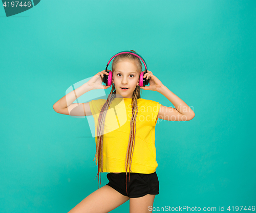 Image of The attractive girl with headphones on blue background