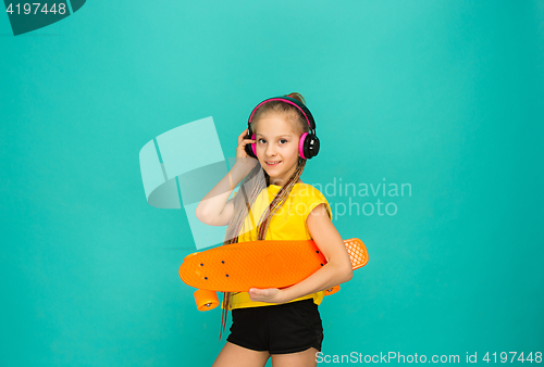 Image of Pretty skater girl holding skateboard