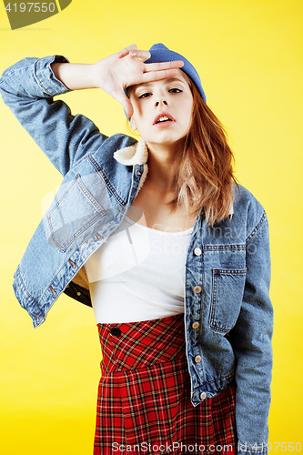 Image of young pretty teenage hipster girl posing emotional happy smiling on yellow background, lifestyle people concept